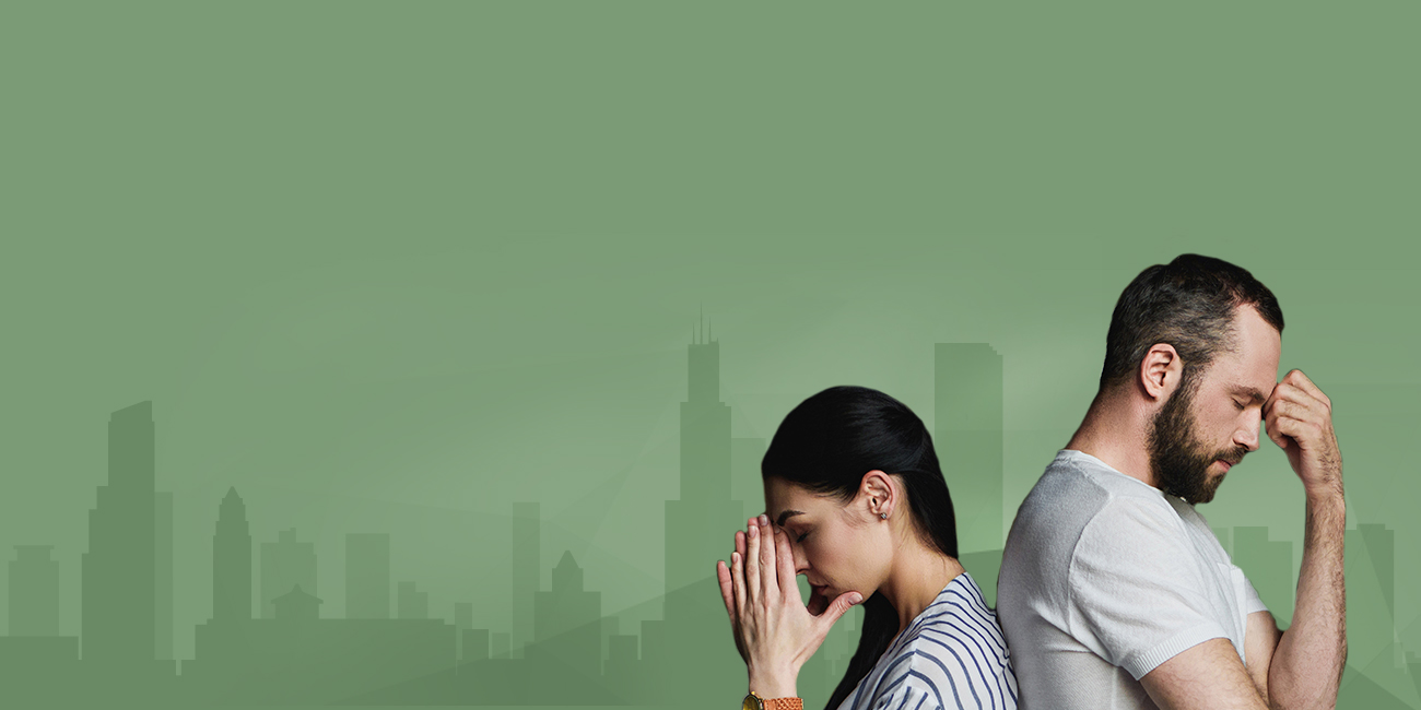 Two individuals, a woman and a man, against a green backdrop featuring a silhouette of a city skyline. The woman, to the left, has her hands clasped near her face in a contemplative or concerned gesture. The man, to the right, has his hand on his forehead, looking distressed or deep in thought.